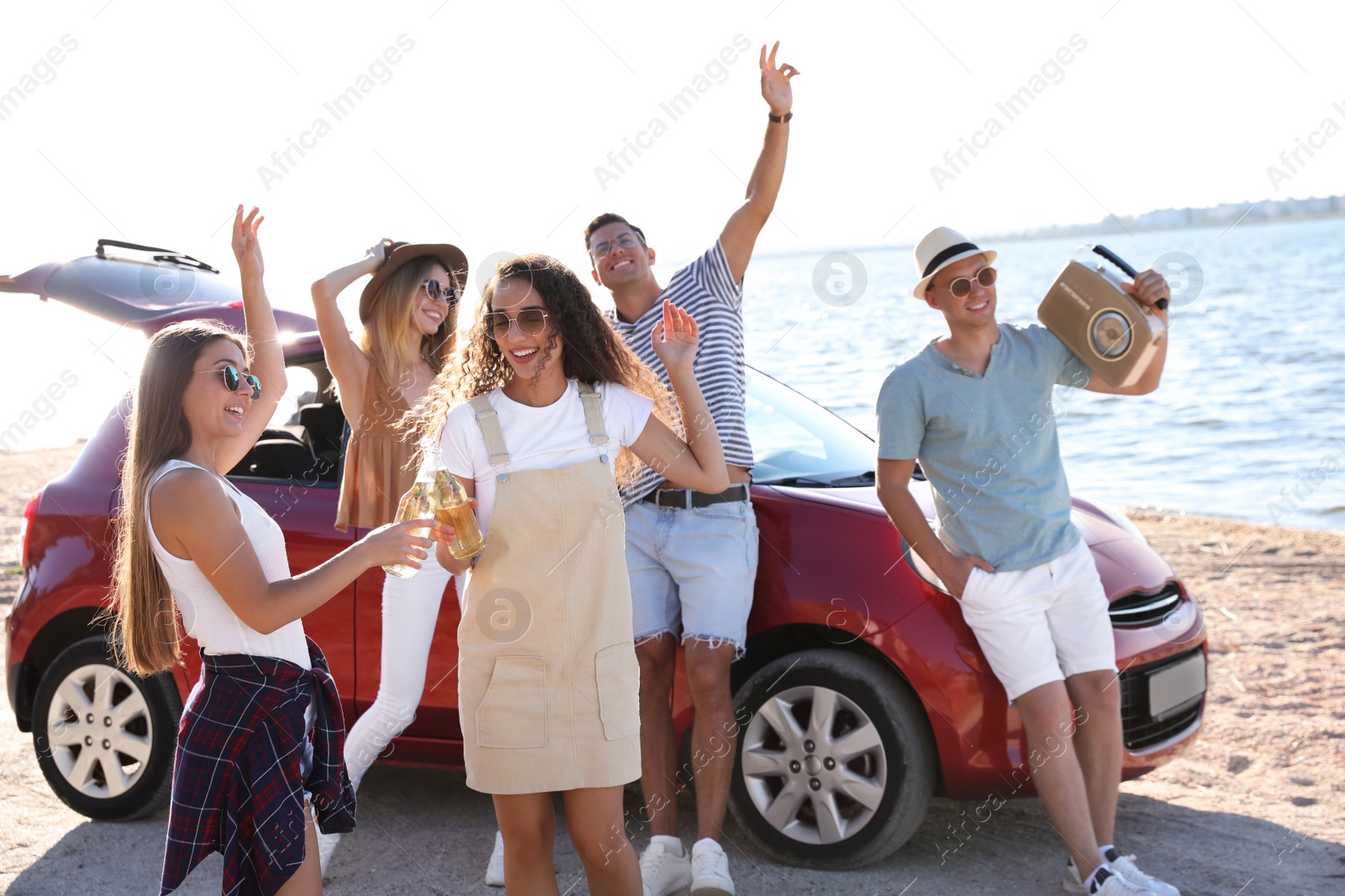 Photo of Happy friends having fun near car on beach. Summer trip