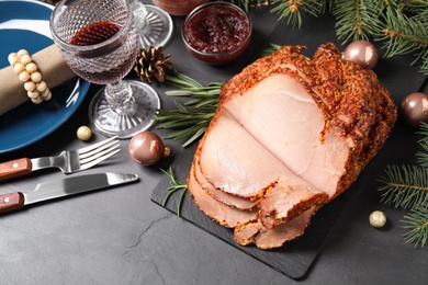 Photo of Delicious Christmas ham served on dark table, above view