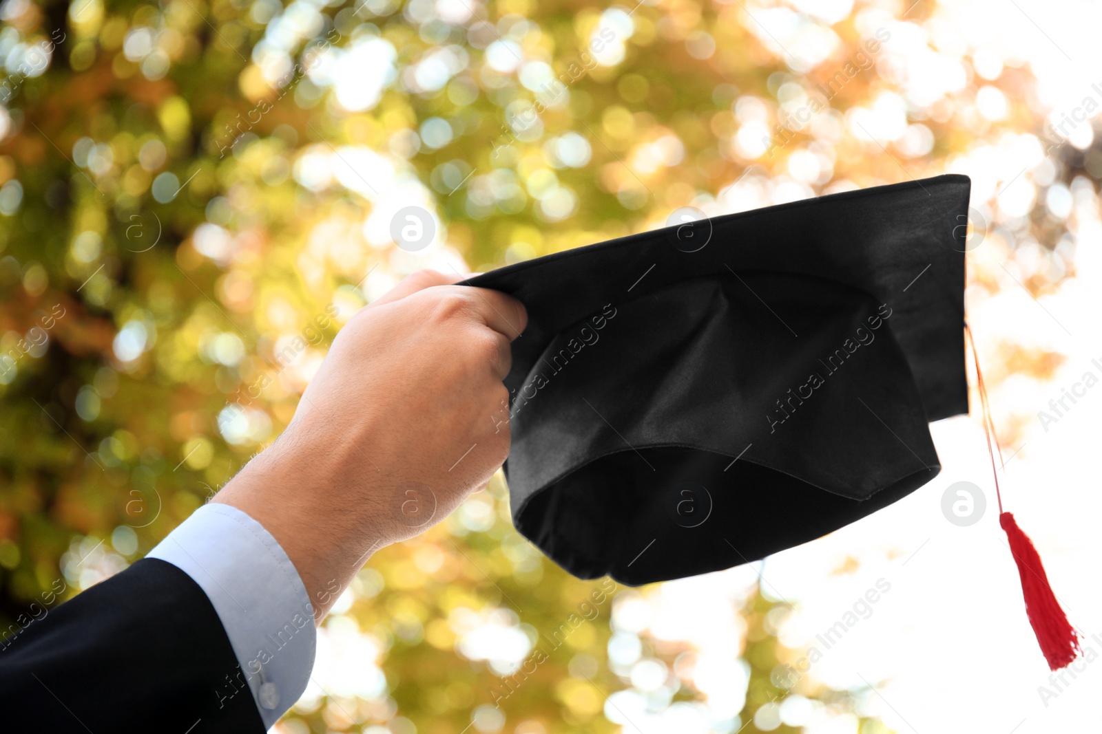 Photo of Student with graduation hat outdoors on sunny day, closeup