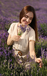 Photo of Young woman with lavender bouquet in field on summer day