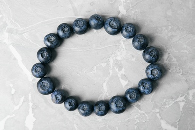 Photo of Frame made with fresh blueberries on grey table, top view. Space for text