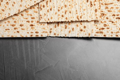 Photo of Traditional matzos on grey table, flat lay. Space for text