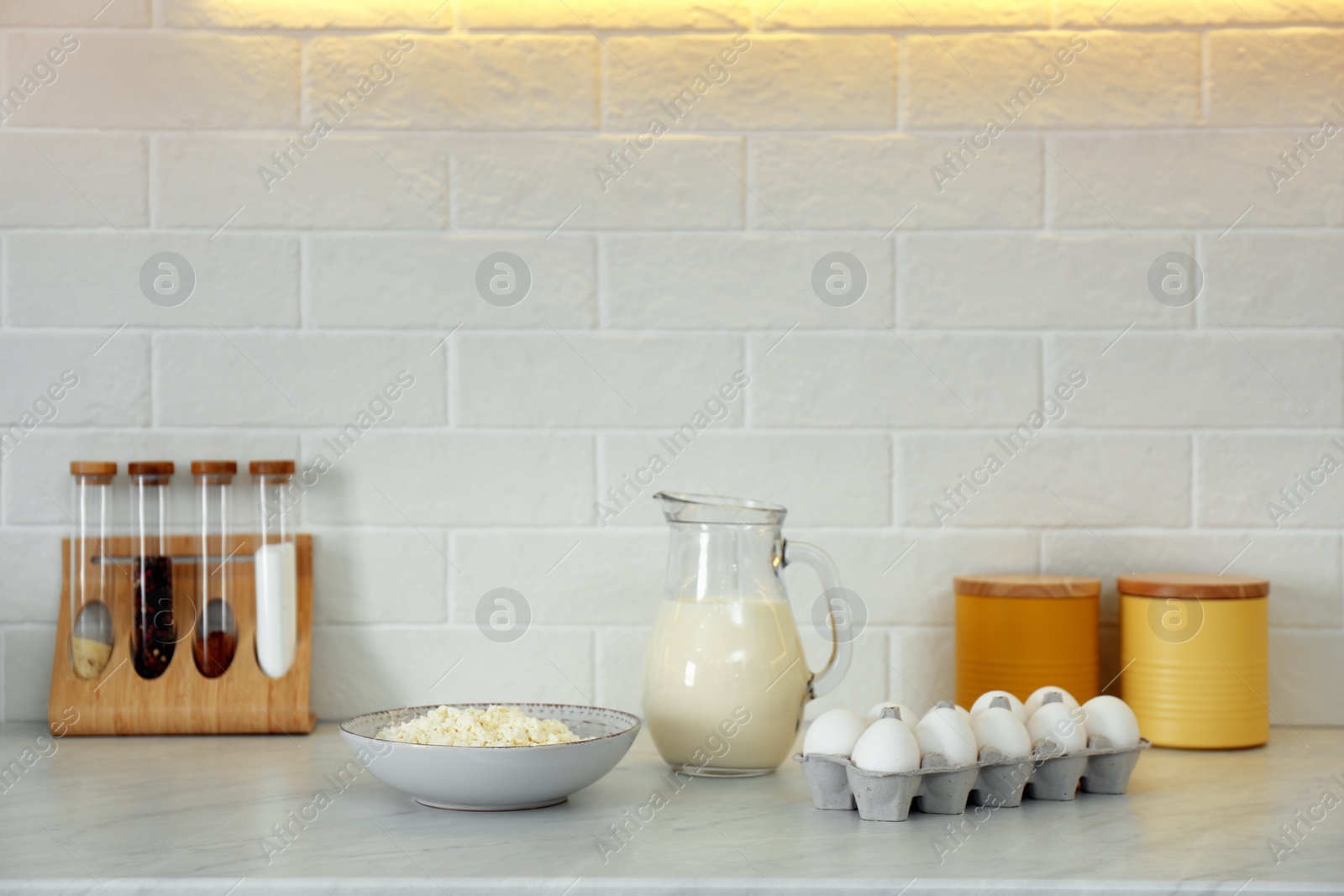 Photo of Different dairy products and eggs on countertop in modern kitchen