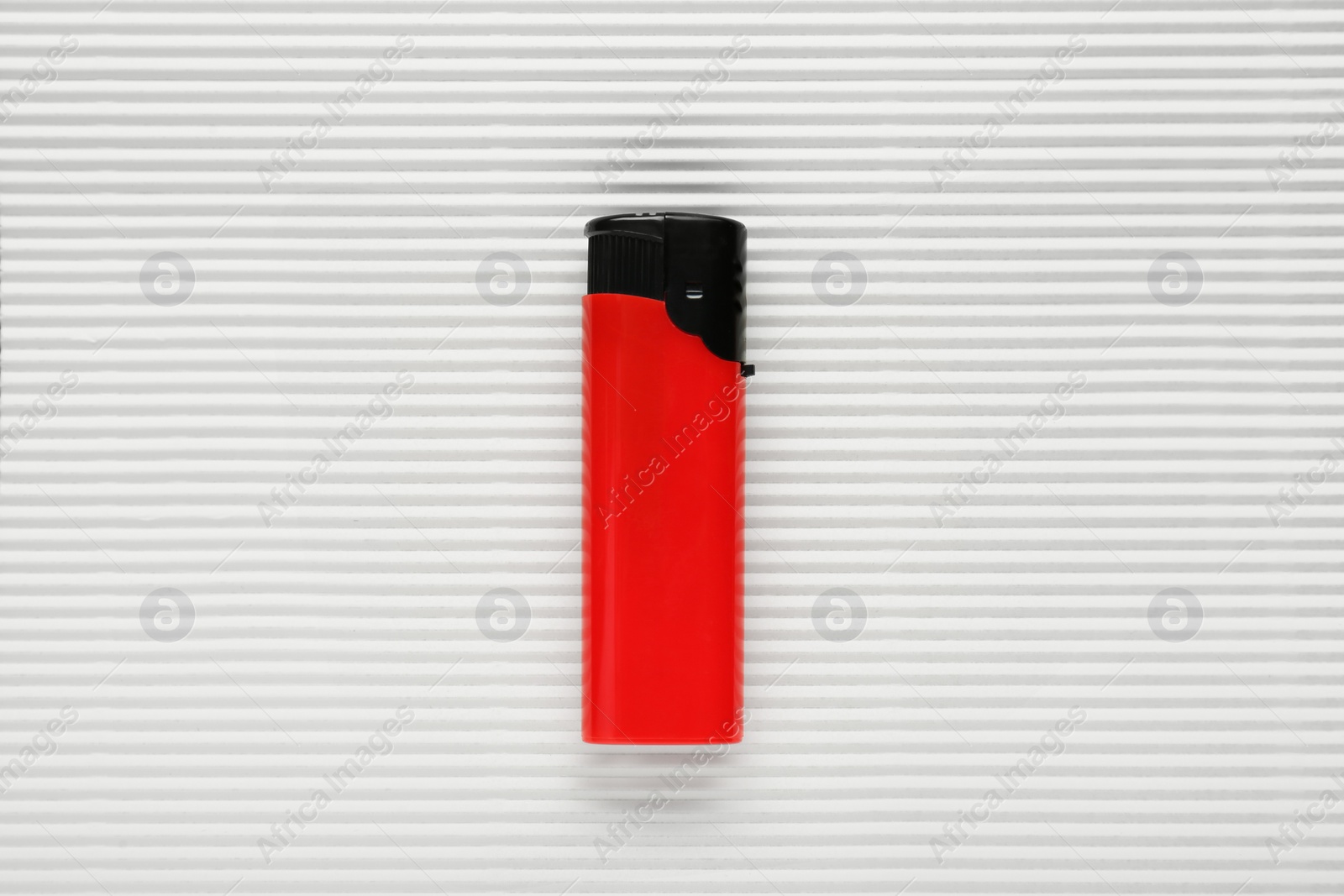 Photo of Stylish small pocket lighter on white corrugated fiberboard, top view
