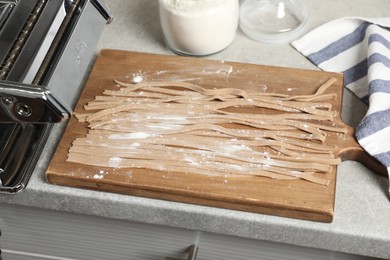 Photo of Uncooked homemade soba with wooden board on table