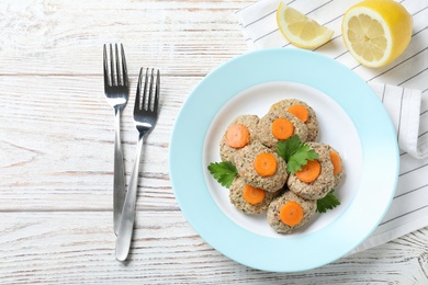 Flat lay composition with plate of traditional Passover (Pesach) gefilte fish on wooden background