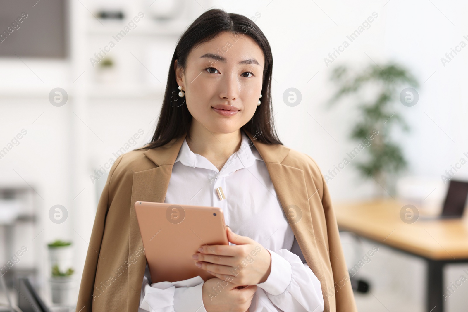 Photo of Portrait of beautiful businesswoman with tablet in office