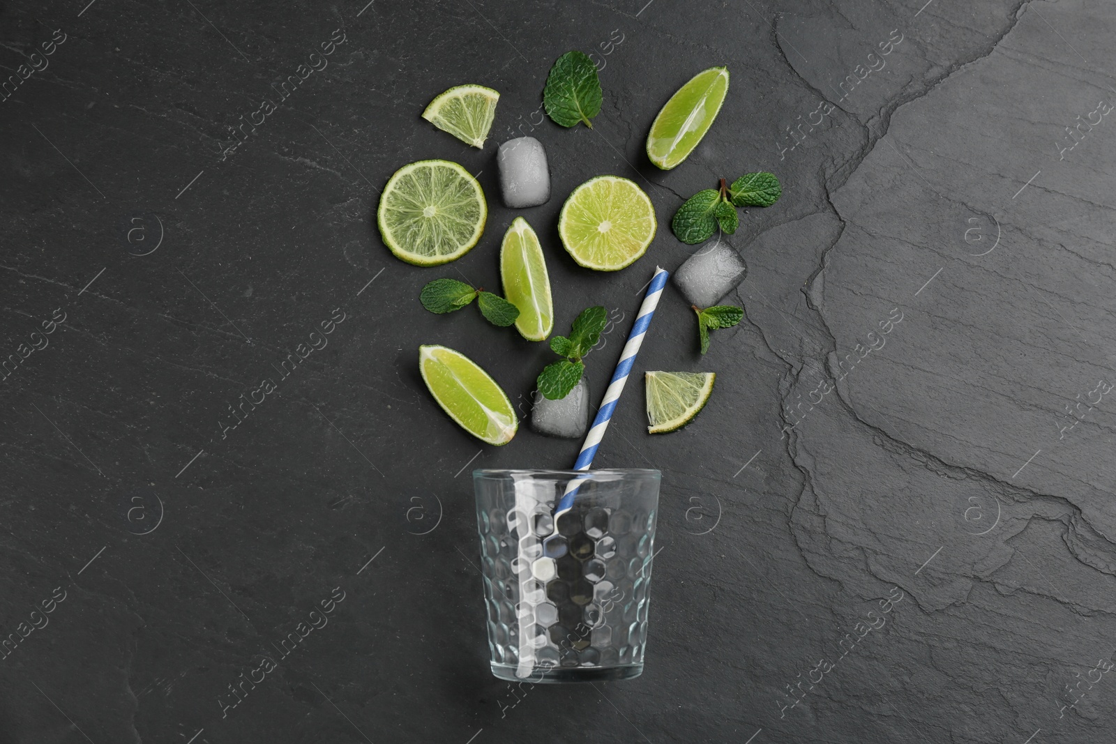 Photo of Creative lemonade layout with lemon slices, ice and mint on black table, top view