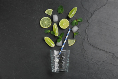 Creative lemonade layout with lemon slices, ice and mint on black table, top view