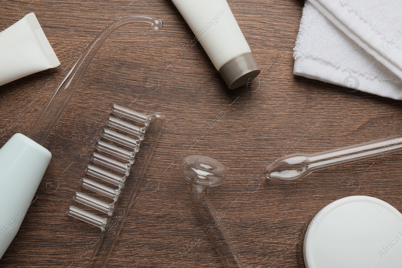 Photo of Flat lay composition with darsonval and different nozzles on wooden table