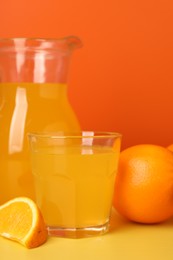 Orange juice and fruit on yellow table, closeup