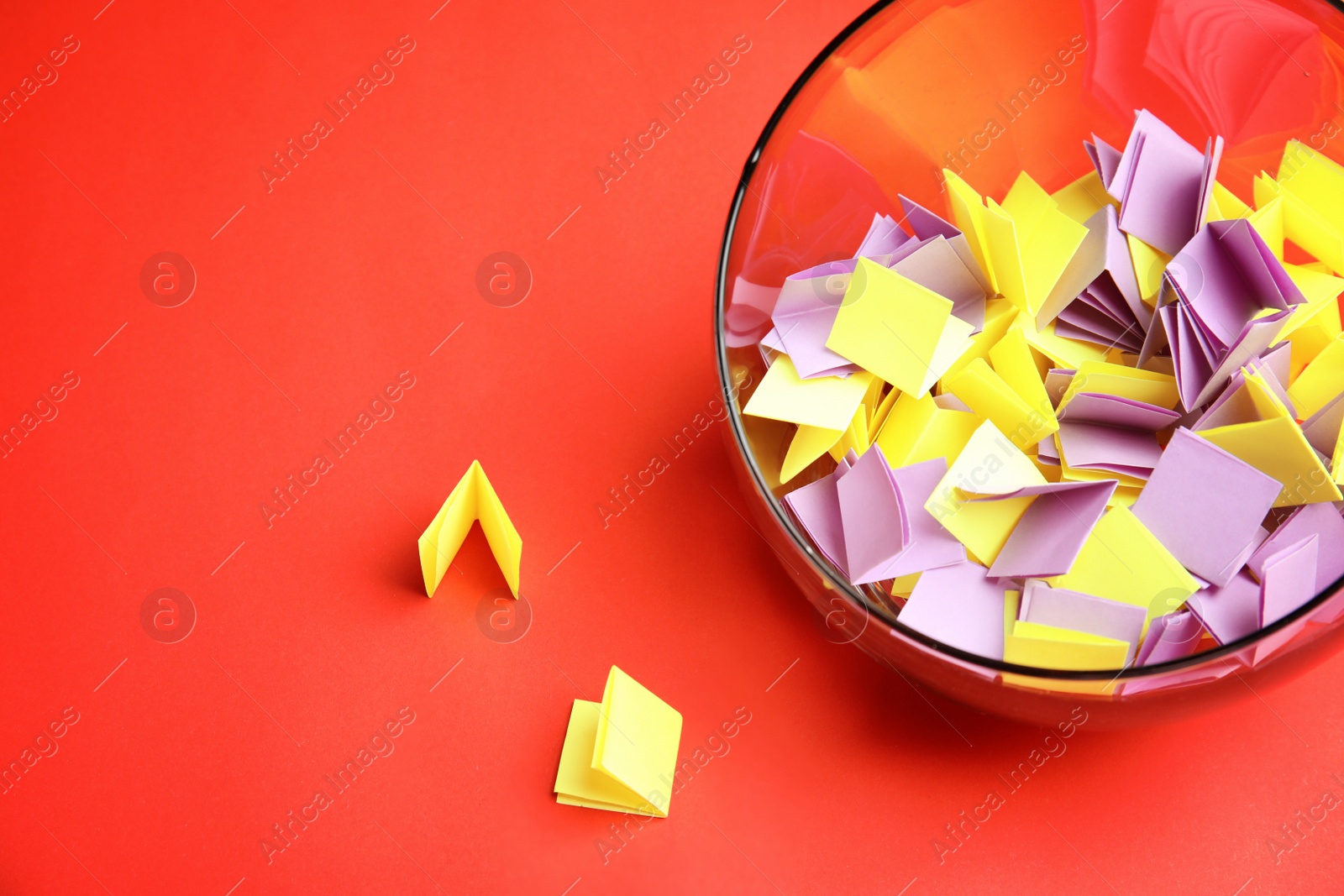 Photo of Paper pieces for lottery in glass vase on color background. Space for text