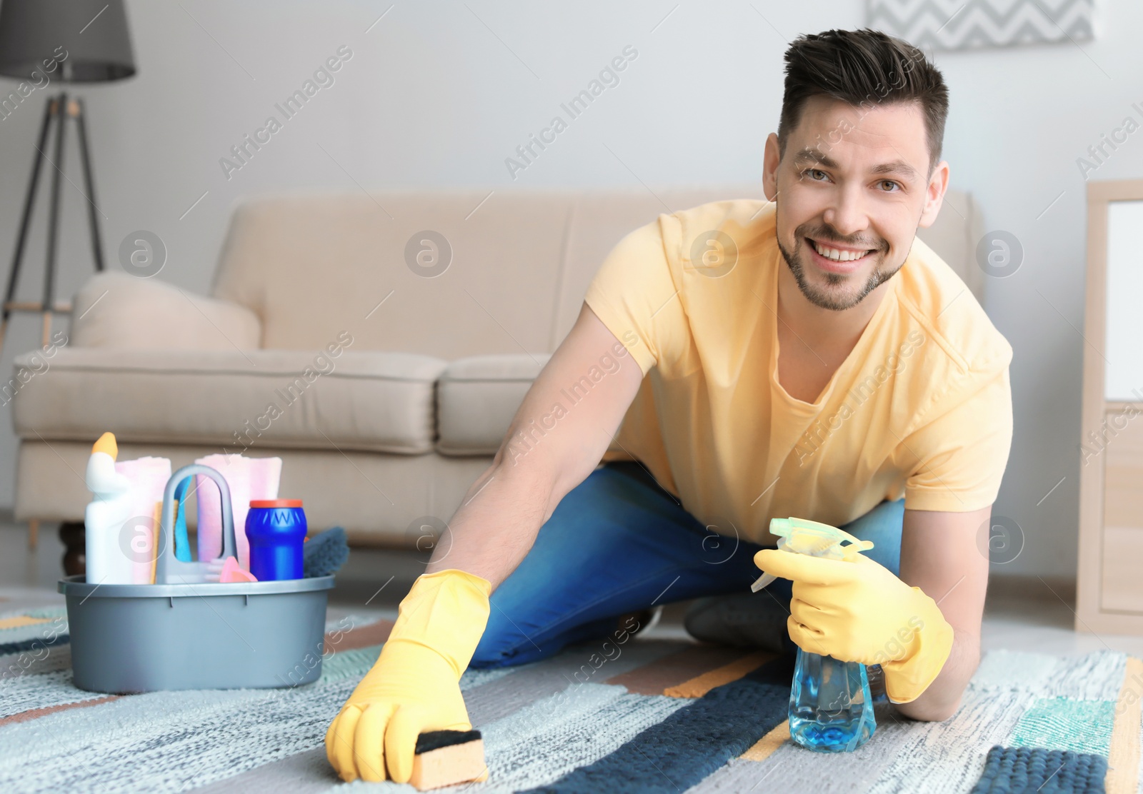 Photo of Mature man cleaning carpet at home