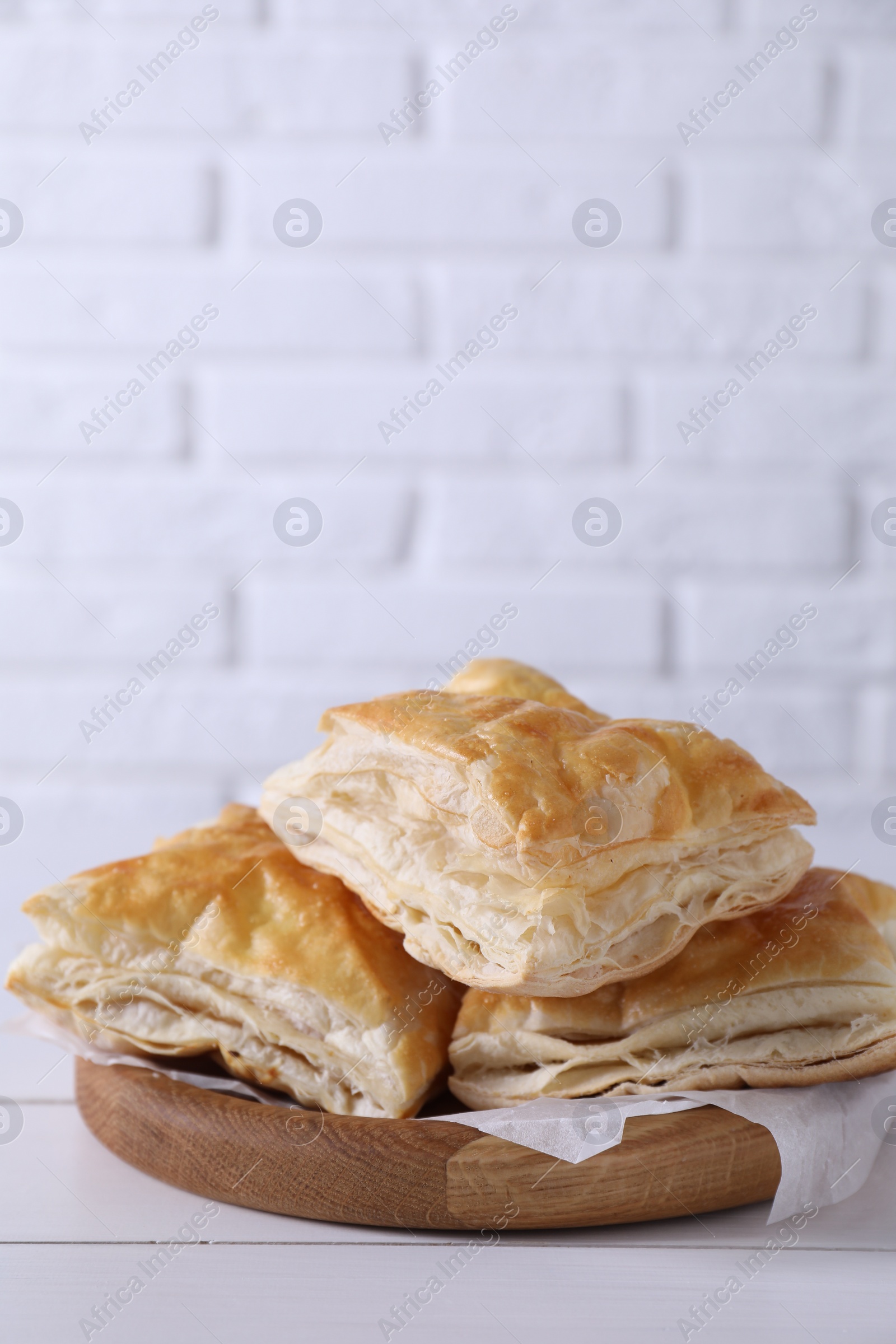 Photo of Delicious puff pastry on white wooden table, space for text