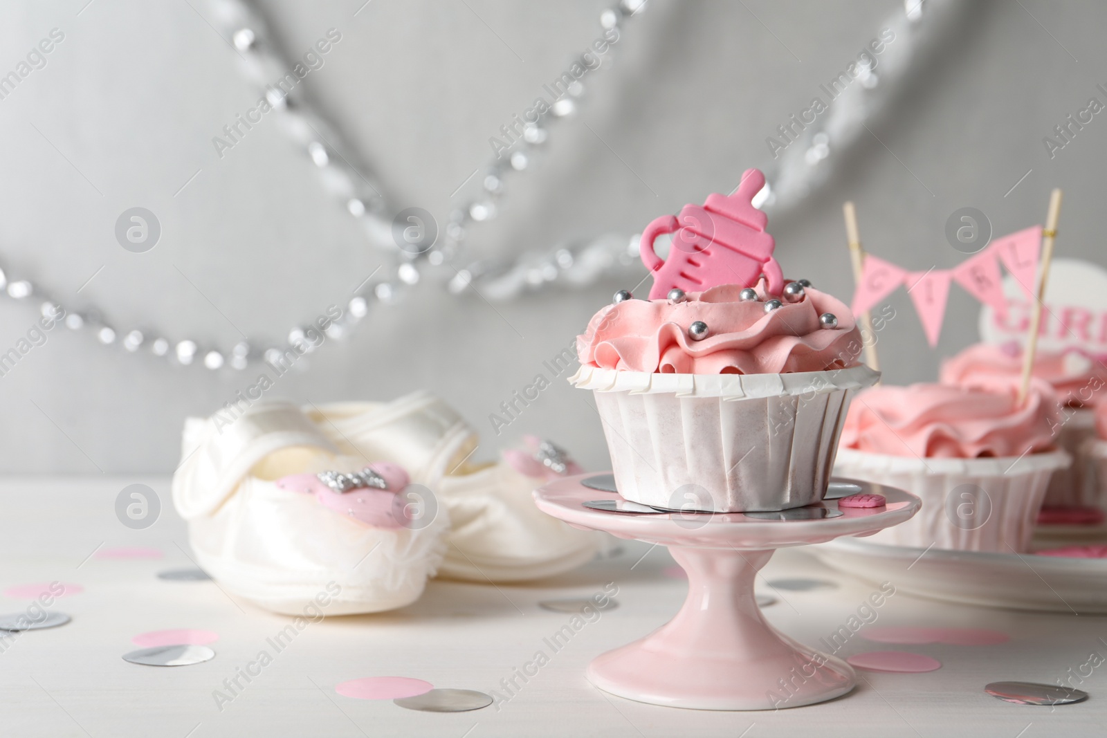 Photo of Delicious cupcake with pink cream and topper on white wooden table, space for text. Baby shower party