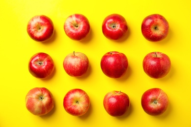 Fresh ripe red apples on yellow background, flat lay