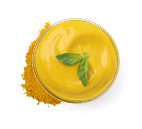 Photo of Bowl with tasty curry sauce, powder and basil isolated on white, top view