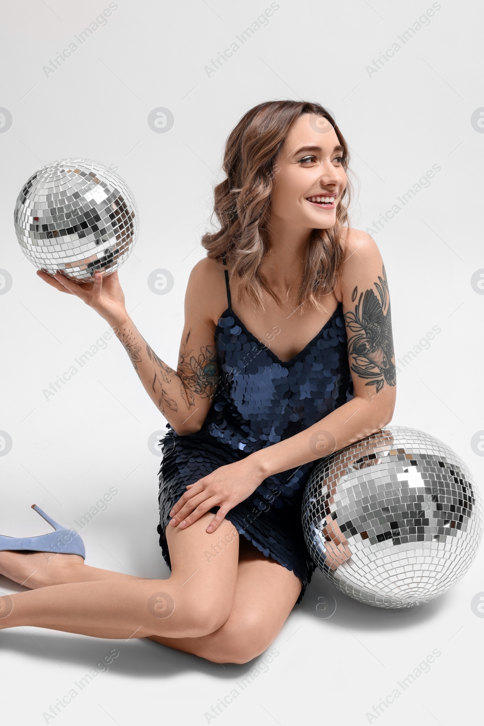 Photo of Beautiful woman with disco balls on white background