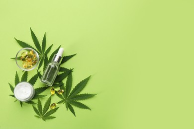 Photo of Flat lay composition with CBD oil or THC tincture and hemp leaves on green background, space for text