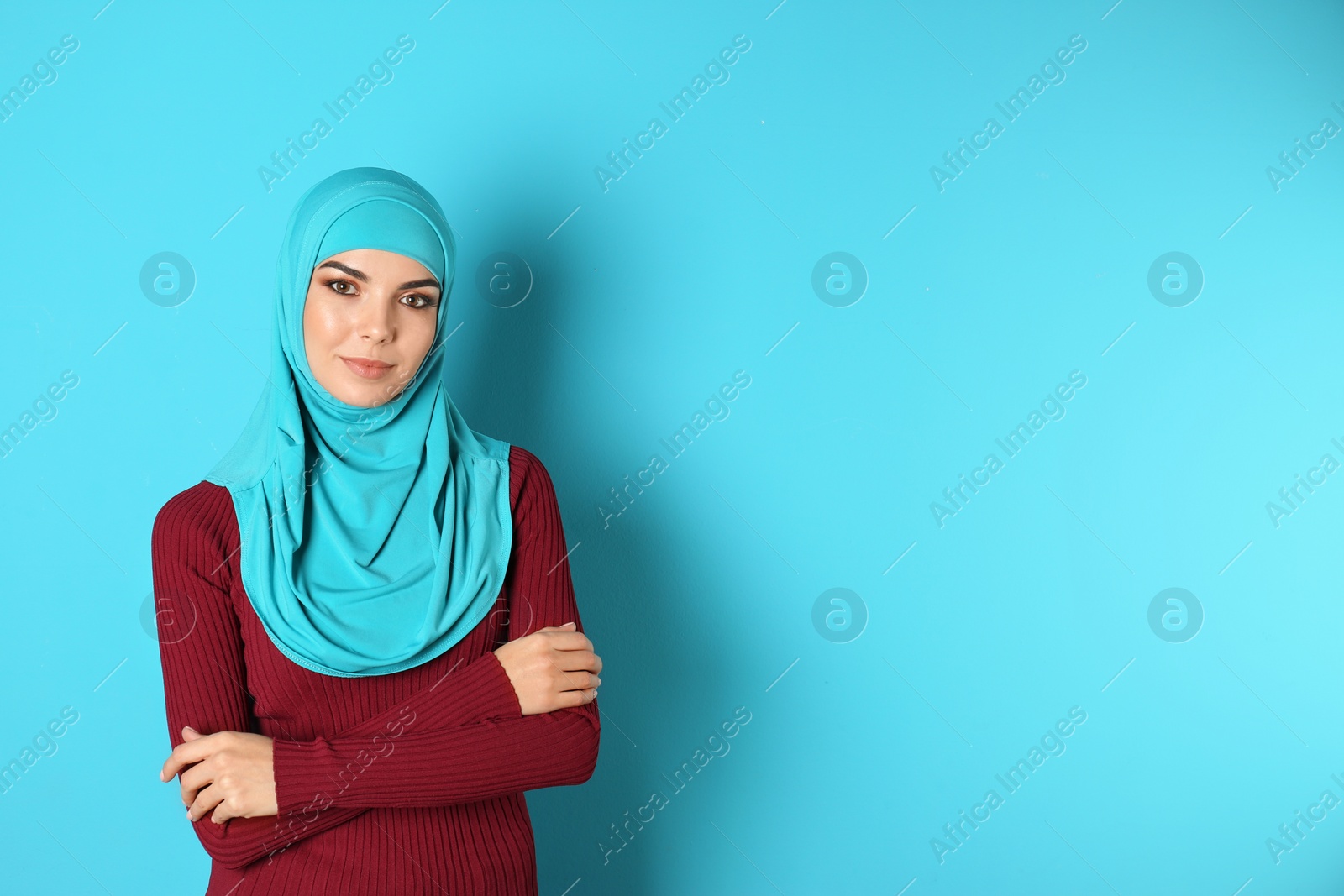 Photo of Portrait of young Muslim woman in hijab against color background. Space for text