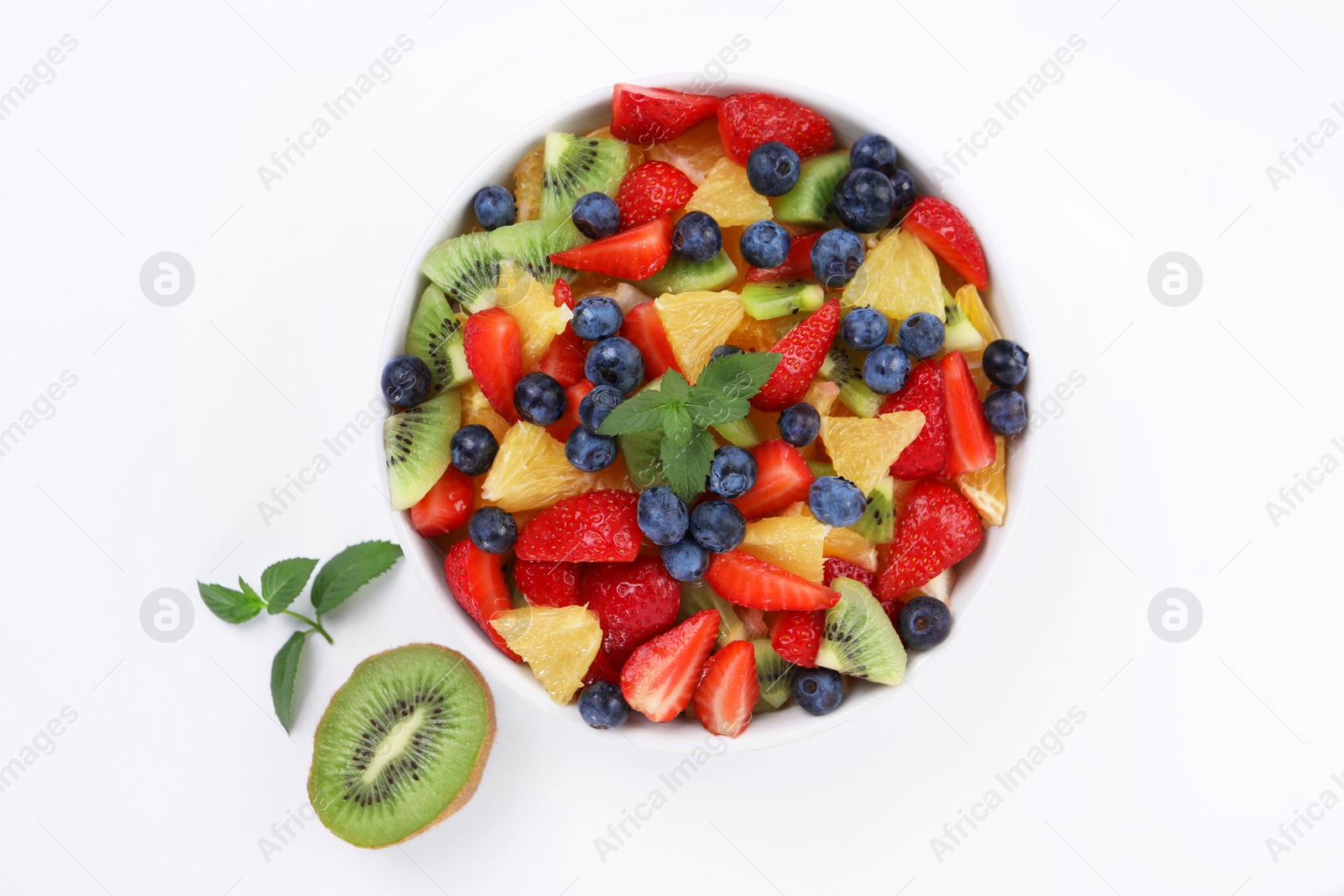 Photo of Yummy fruit salad in bowl on white background, top view