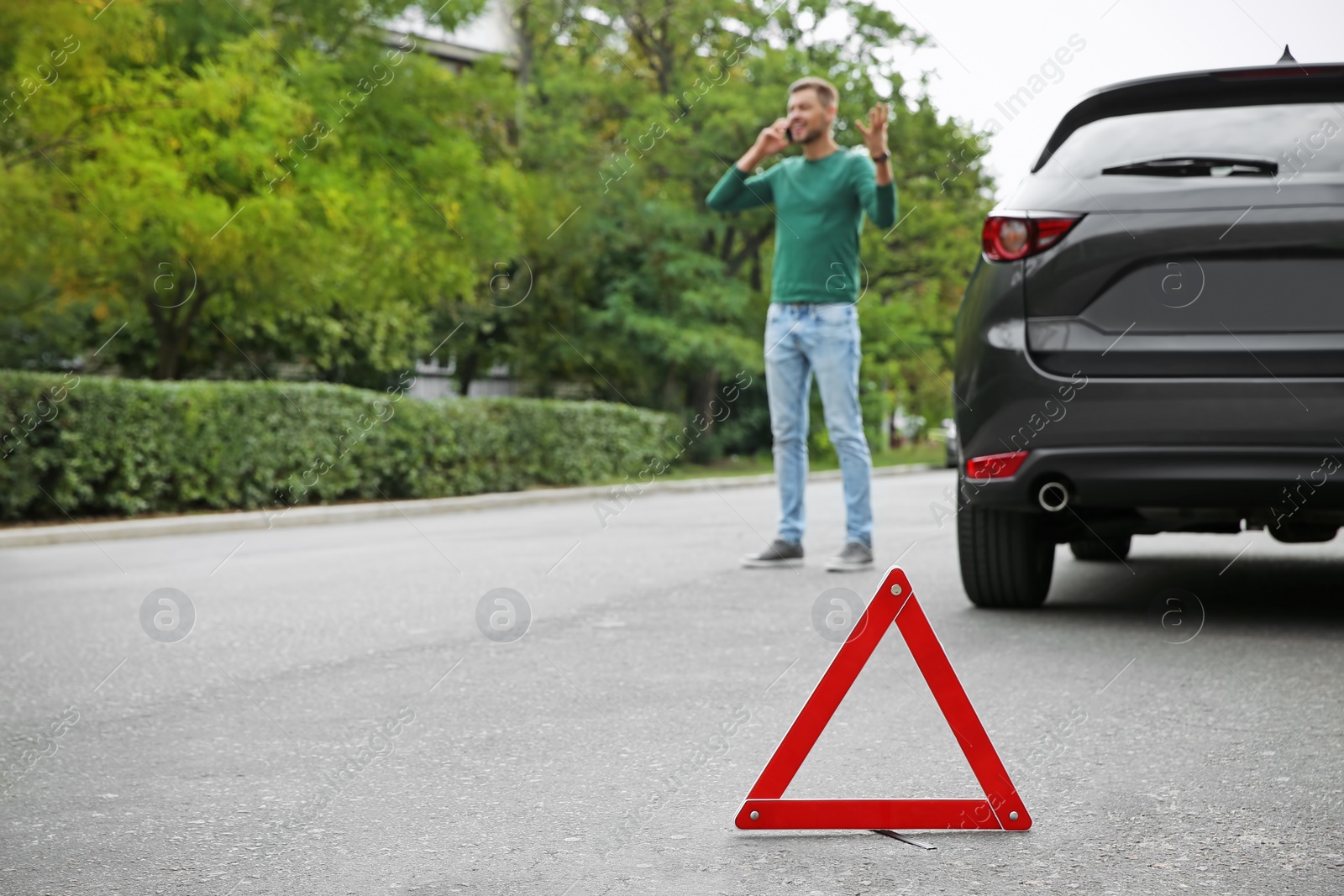 Photo of Emergency stop sign and man near broken car on background