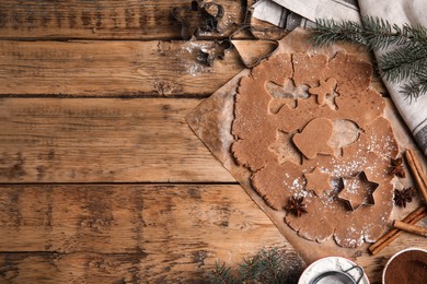 Photo of Making Christmas cookies. Flat lay composition with raw dough and cutters on wooden table