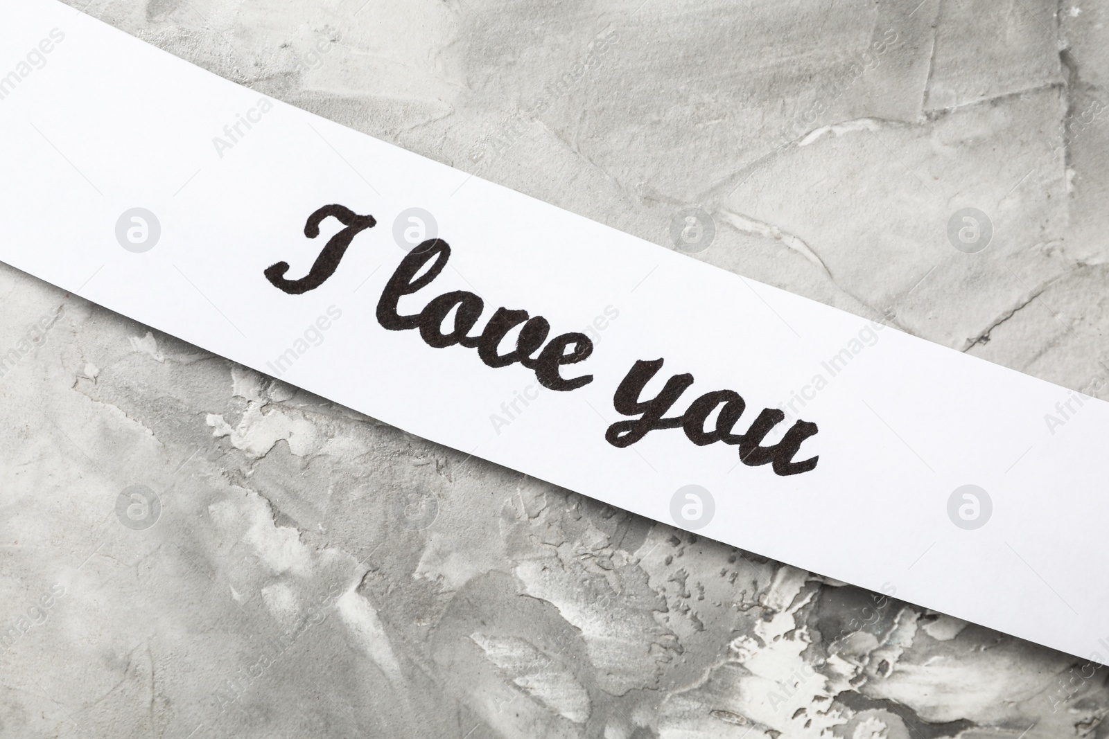 Photo of Card with text I Love You on light grey stone background, top view