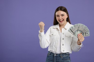 Excited woman with dollar banknotes on purple background, space for text