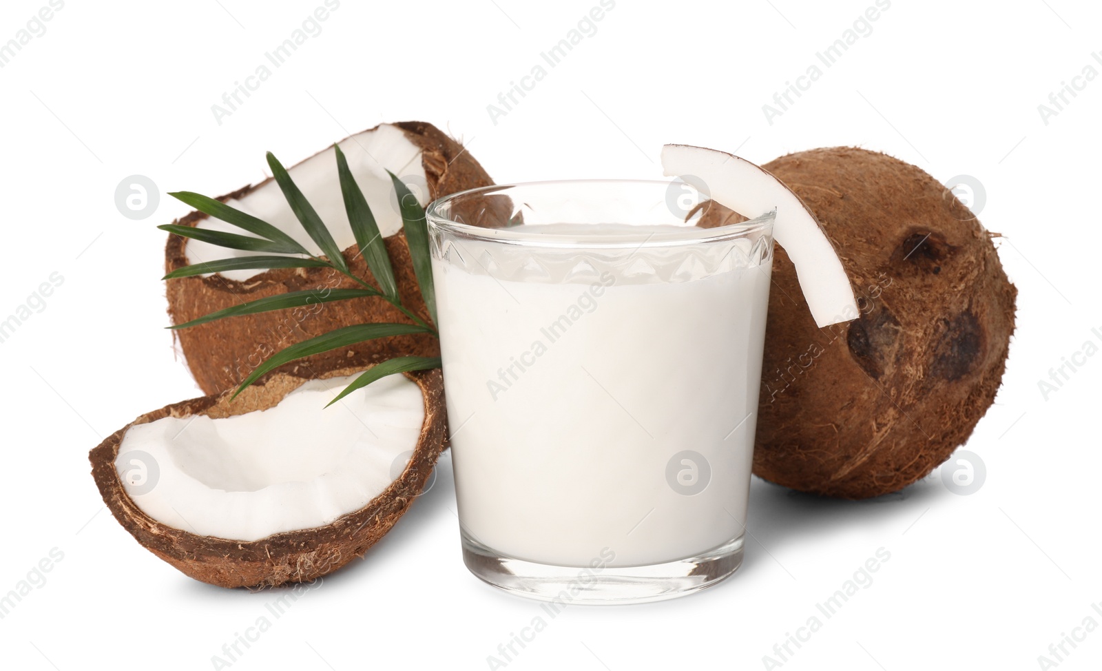 Photo of Glass of delicious vegan milk, coconuts and green leaves on white background