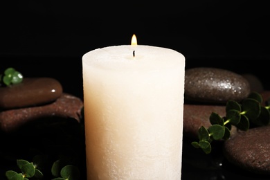 Photo of Composition with candle and spa stones on black background