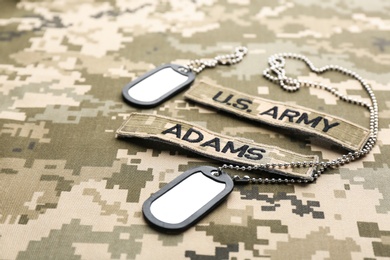 Photo of Military ID tags and patches on camouflage background