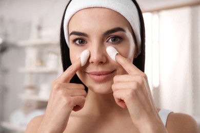 Photo of Woman using silkworm cocoons in skin care routine at home, closeup