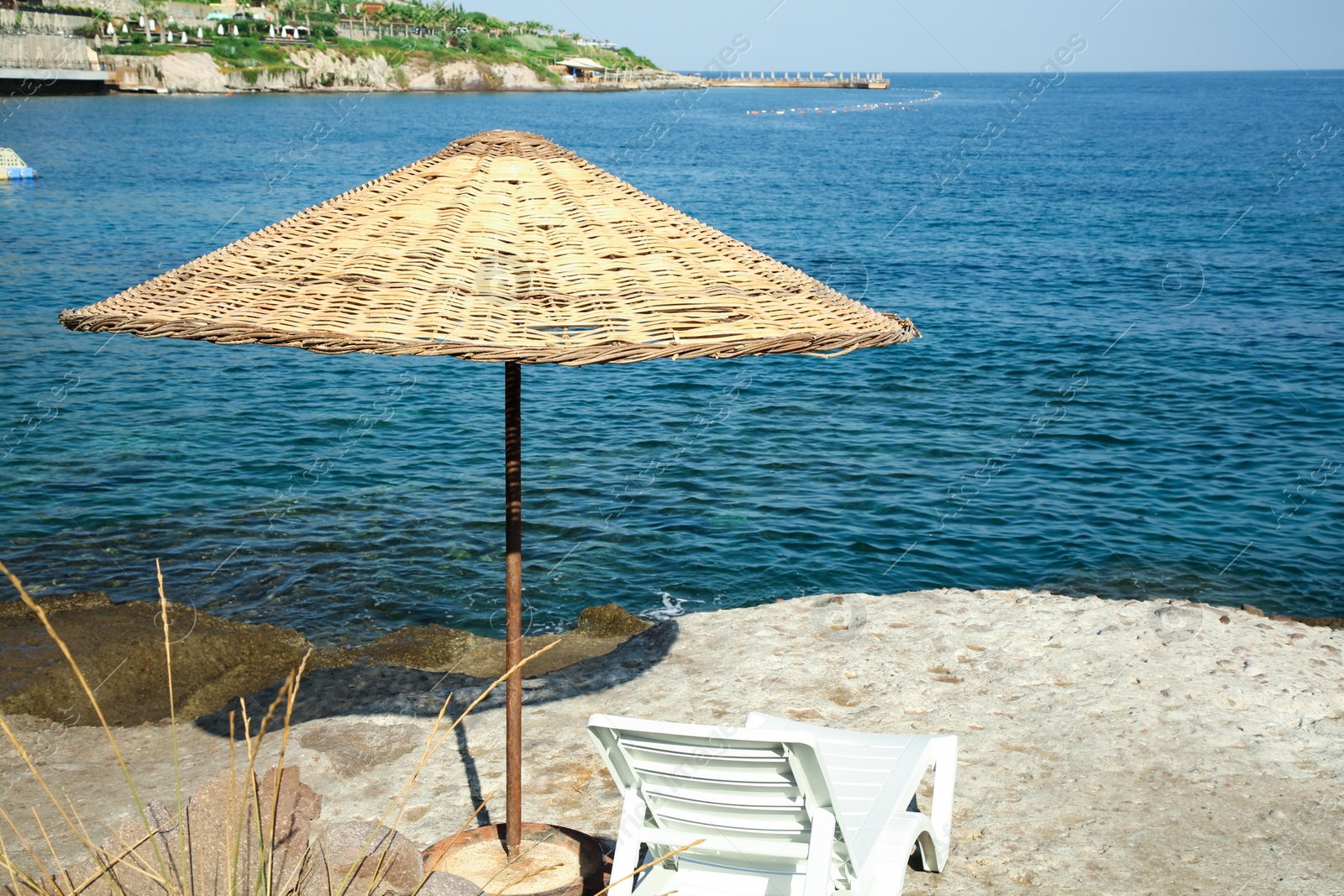 Photo of Lounge chair and beach umbrella on sea shore