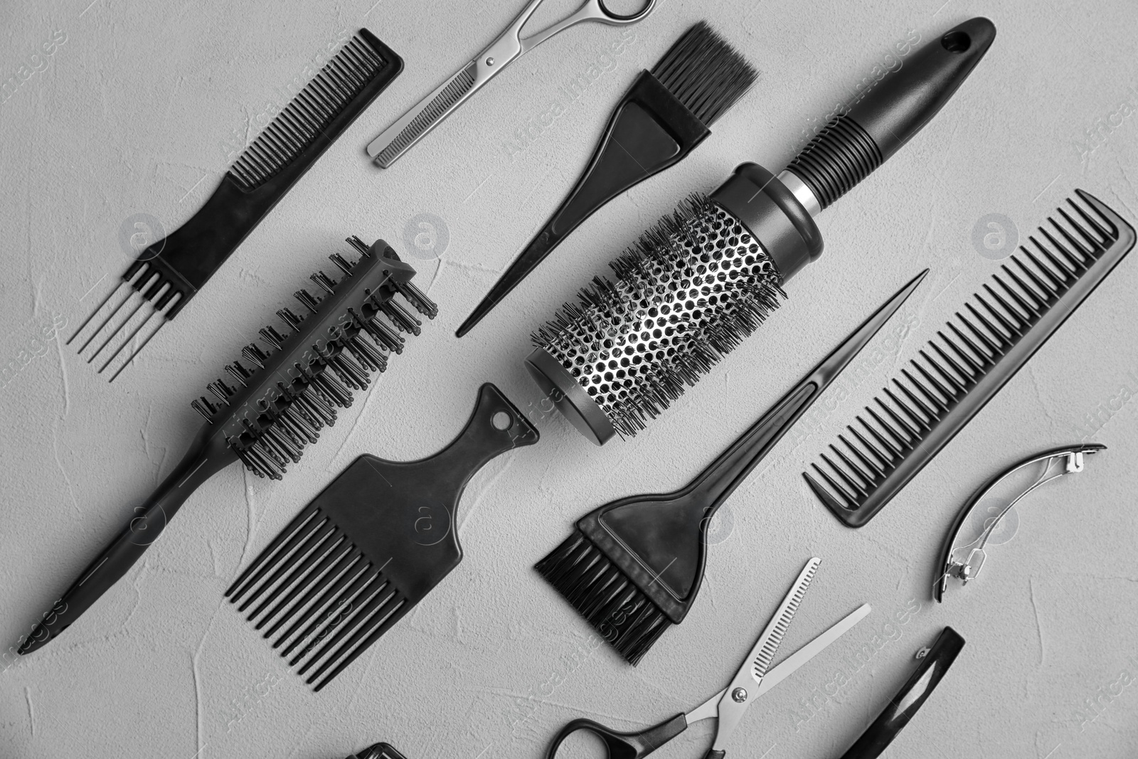 Photo of Flat lay composition with professional hairdresser tools on grey background