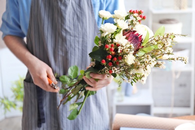 Male florist pruning stems at workplace