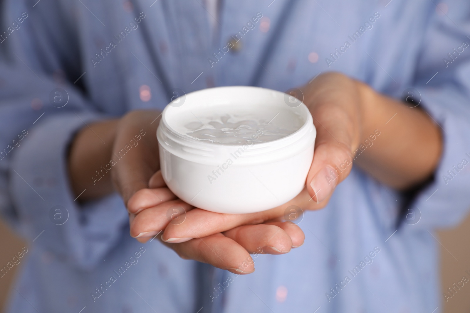 Photo of Woman with jar of moisturizing cream, closeup