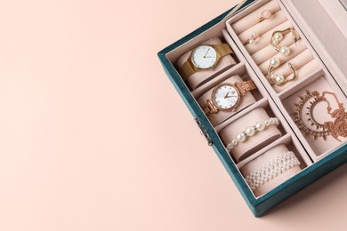 Photo of Jewelry box with many different accessories on beige background, top view. Space for text