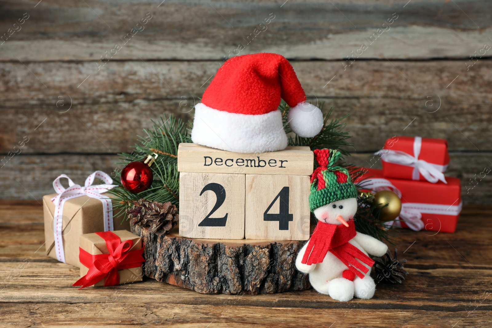 Photo of December 24 - Christmas Eve. Wooden block calendar and festive decor on table