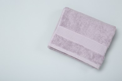 Photo of Violet terry towel on light grey background, top view. Space for text