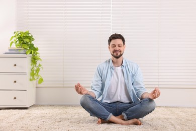 Man meditating at home. Harmony and zen
