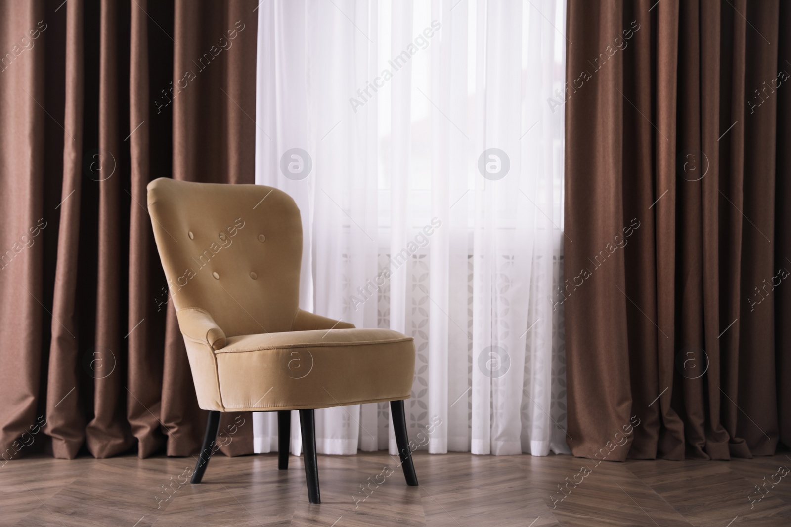 Photo of Comfortable armchair near window indoors, space for text. Interior design