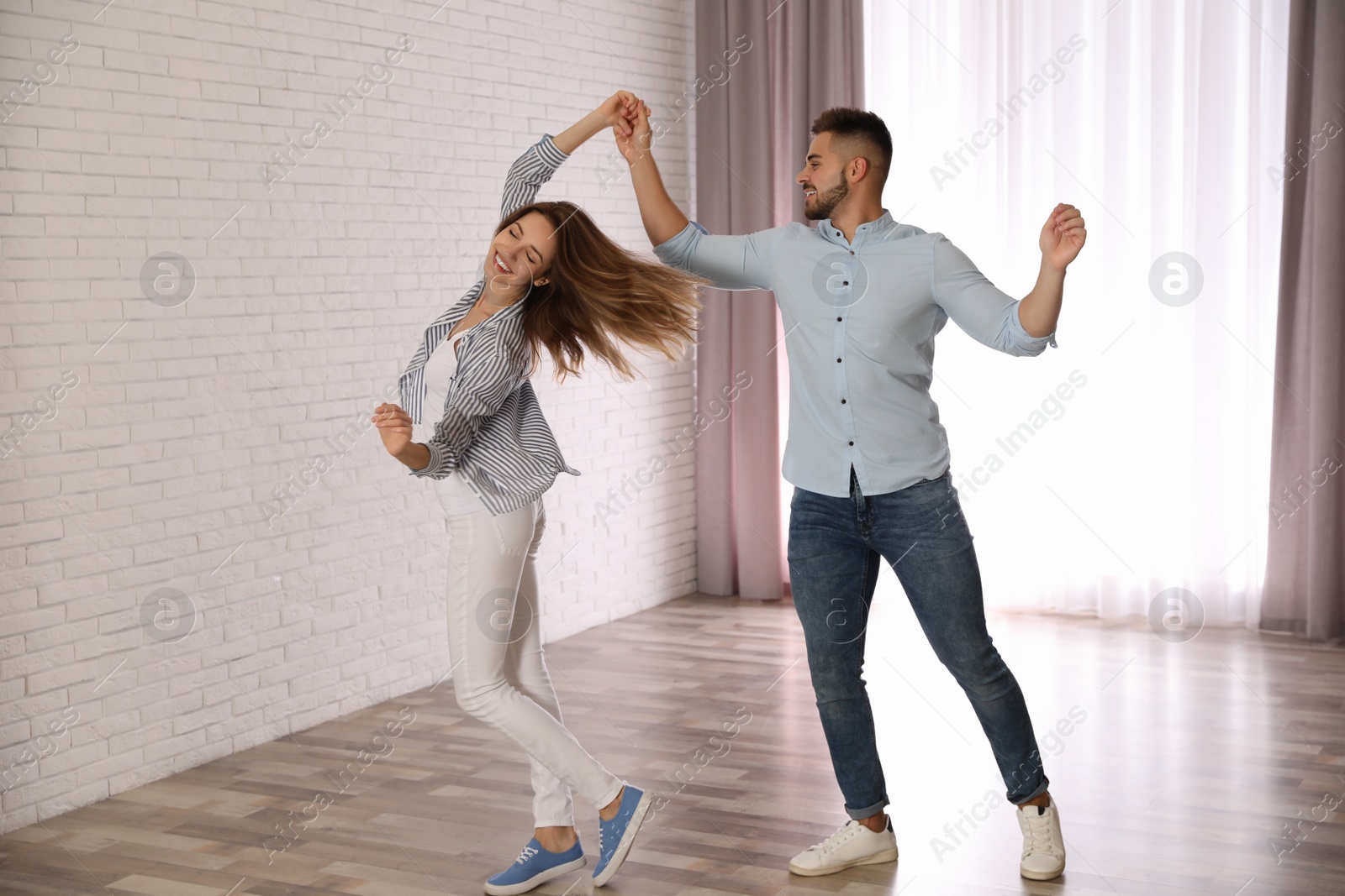 Photo of Lovely young couple dancing together at home