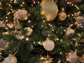 Photo of Beautiful Christmas tree decorated with baubles and festive lights as background, closeup