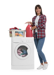 Photo of Beautiful woman with detergent and laundry basket on washing machine against white background
