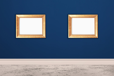 Image of Frames with empty canvases on blue wall in modern art gallery. Space for design