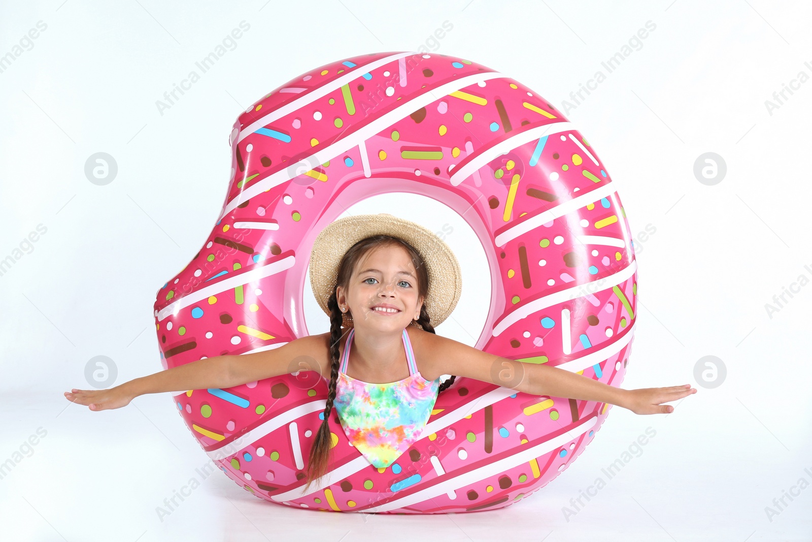 Photo of Cute little child in beachwear with bright inflatable ring on white background