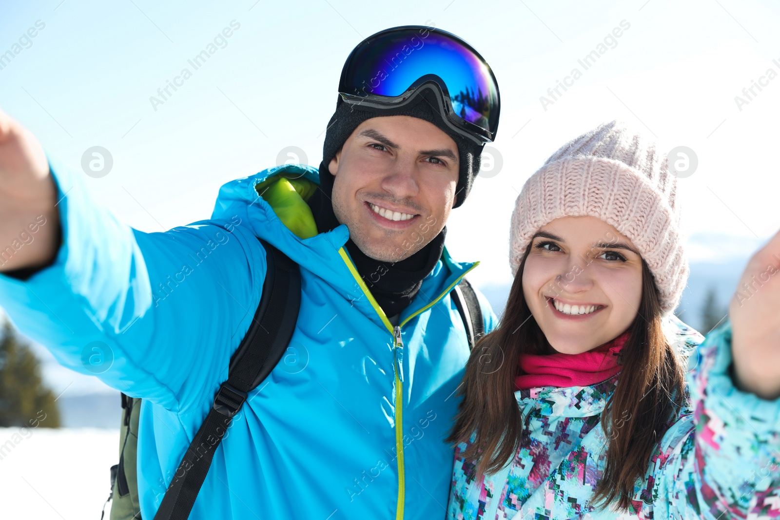 Photo of Happy couple taking selfie in mountains. Winter vacation