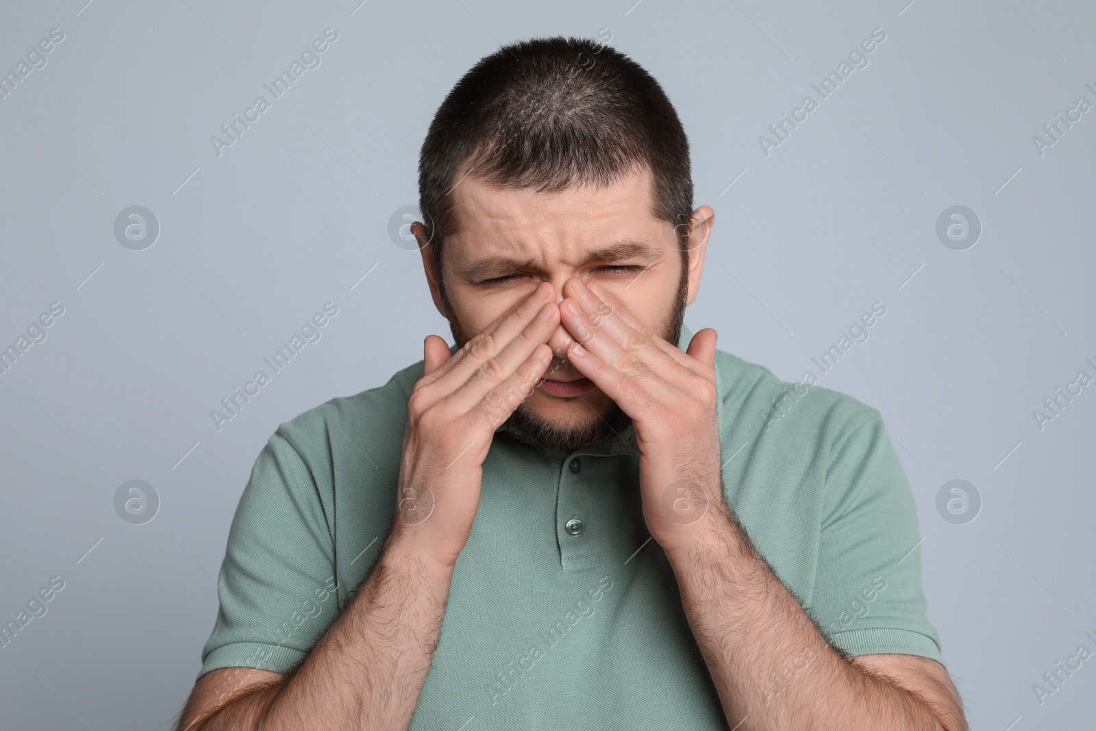 Photo of Man suffering from headache on light grey background