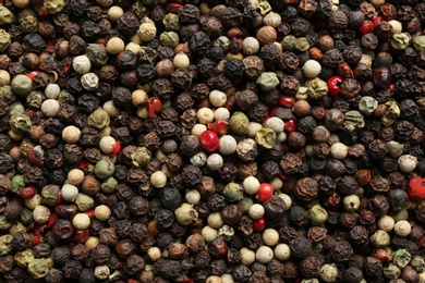 Photo of Many different peppercorns as background, top view